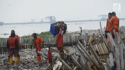 Petugas mengangkut sampah plastik yang menumpuk di kawasan wisata hutan Mangrove Muara Angke, Jakarta, Sabtu (17/3). (Merdeka.com/Imam Buhori)