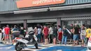 Orang-orang mengantre di luar supermarket di Noumea di tengah protes terkait perdebatan mengenai rancangan undang-undang konstitusi yang bertujuan untuk memperbesar jumlah pemilih untuk pemilu mendatang di wilayah luar negeri Prancis, Kaledonia Baru, Kamis (16/5/2024). (Delphine Mayeur / AFP)