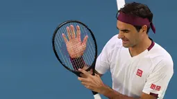 Petenis Swiss, Roger Federer merayakan kemenangannya atas Tennys Sandgren dari Amerika Serikat pada babak perempat final tunggal putra Australia Terbuka di Melbourne, Selasa (28/1/2020). Federer melaju ke semifinal usai mengalahkan Sandgren. (DAVID GRAY/AFP)