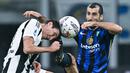 Pemain Inter Milan, Henrikh Mkhitaryan, berebut bola dengan pemain Juventus, Andrea Cambiaso, pada laga Liga Italia di Stadion Giuseppe Meazza, Minggu (27/10/2024). (AFP/Gabriel Bouys)
