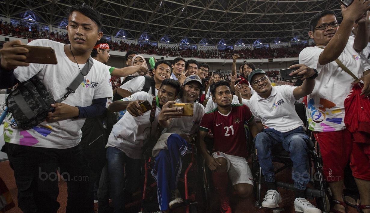 Gelandang Timnas Indonesia, Andik Vermansah, foto bersama penonton difabel usai melawan Islandia pada laga persahabatan di SUGBK, Jakarta, Minggu (14/1/2018). Timnas Indonesia kalah 1-4 dari Islandia. (Bola.com/Vitalis Yogi Trisna)