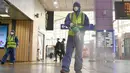 Seorang pekerja mengenakan pakaian pelindung saat menyemprotkan Disinfektan sebagai tindakan pencegahan virus corona COVID-19 di sebuah stasiun kereta api di Daegu, Korea Selatan  (26/2/2020). Jumlah infeksi corona di Korea Selatan melonjak lagi pada Rabu (26/2). (AFP Photo/Jung Yeon-je)