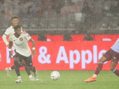 Hujan deras yang turun saat laga uji coba antara Manchester United melawan Aston Villa di Optus Stadium, Perth, Sabtu (23/7/2022) membuat pergerakan sejumlah pemain agak terhambat. (AFP/Trevor Collens)
