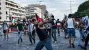 Pengunjuk rasa melempar batu ke kedutaan Israel pada unjuk rasa di Athena, Yunani, Selasa (15/5). Mereka mengecam tentara Israel menembak mati puluhan warga Palestina di perbatasan Gaza yang berunjuk rasa menentang pembukaan kedubes AS (AFP/Aris MESSINIS)