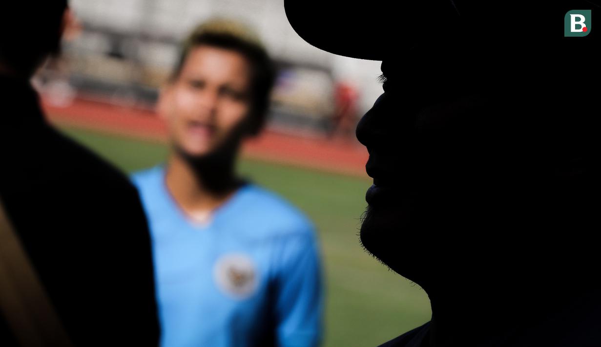 Siluet pelatih kepala Timnas Wanita Indonesia, Rudy Eka Priyambada saat melakukan wawancara seusai sesi latihan persiapan Piala Asia Wanita 2022 di Stadion Madya, Jakarta, Jumat (07/01/2021). (Bola.com/Bagaskara Lazuardi)
