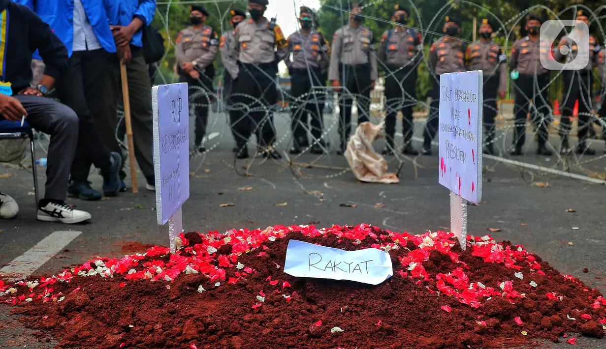 Mahasiswa melakukan aksi teatrikal membuat kuburan di tengah jalan saat aksi unjuk rasa atau demo BBM naik di kawasan Patung Kuda, Jakarta, Senin (5/9/2022). Kenaikan harga BBM ini kemudian memicu reaksi publik secara luas. Mahasiswa kemudian berdemo dan dijadwalkan massa buruh juga akan turun ke jalan. (Liputan6.com/Angga Yuniar)
