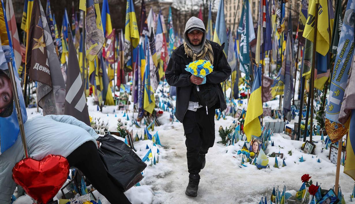 Konflik ini telah berkembang menjadi perang yang paling mematikan di Eropa sejak Perang Dunia II. Tampak dalam foto, seorang warga setempat mengunjungi tugu peringatan sementara untuk tentara Ukraina di Lapangan Kemerdekaan, Kyiv, saat peringatan keempat invasi Rusia ke Ukraina, Selasa 24 Februari 2026. (HENRY NICHOLLS/AFP)