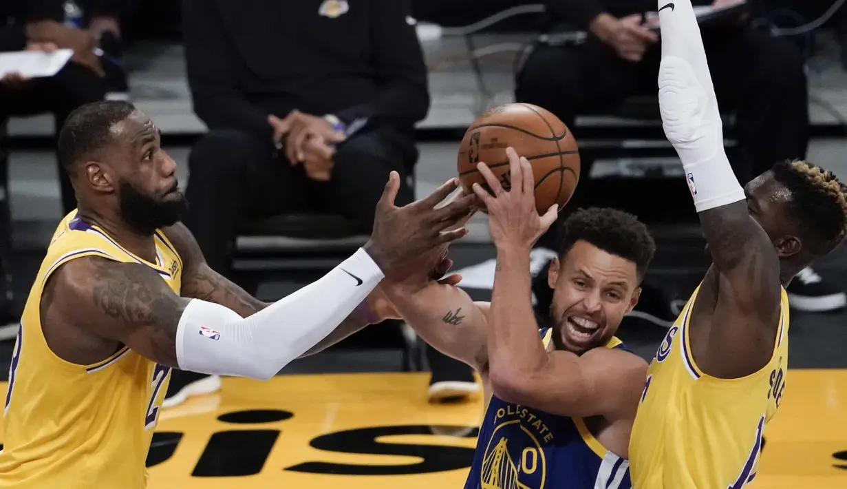 Pebasket LA Lakers LeBron James (kiri) dan Dennis Schroder (kanan) berupaya menghadang pebasket Golden State Warriors Stephen Curry dalam pertandingan NBA di Staples Center,  Los Angeles, California, Amerika Serikat, Senin (18/1/2020). (AP Photo/Jae C. Hong)