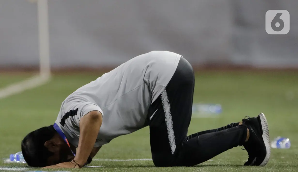 Pelatih Timnas Indonesia U-22, Indra Sjafri, sujud syukur usai mengalahkan Timnas Singapura U-22 dalam pertandingan Grup B SEA Games 2019 di Stadion Rizal Memorial, Manila, Kamis (28/11/2019). Indonesia menang dengan skor 2-0 atas Singapura. (Bola.com/M Iqbal Ichsan)