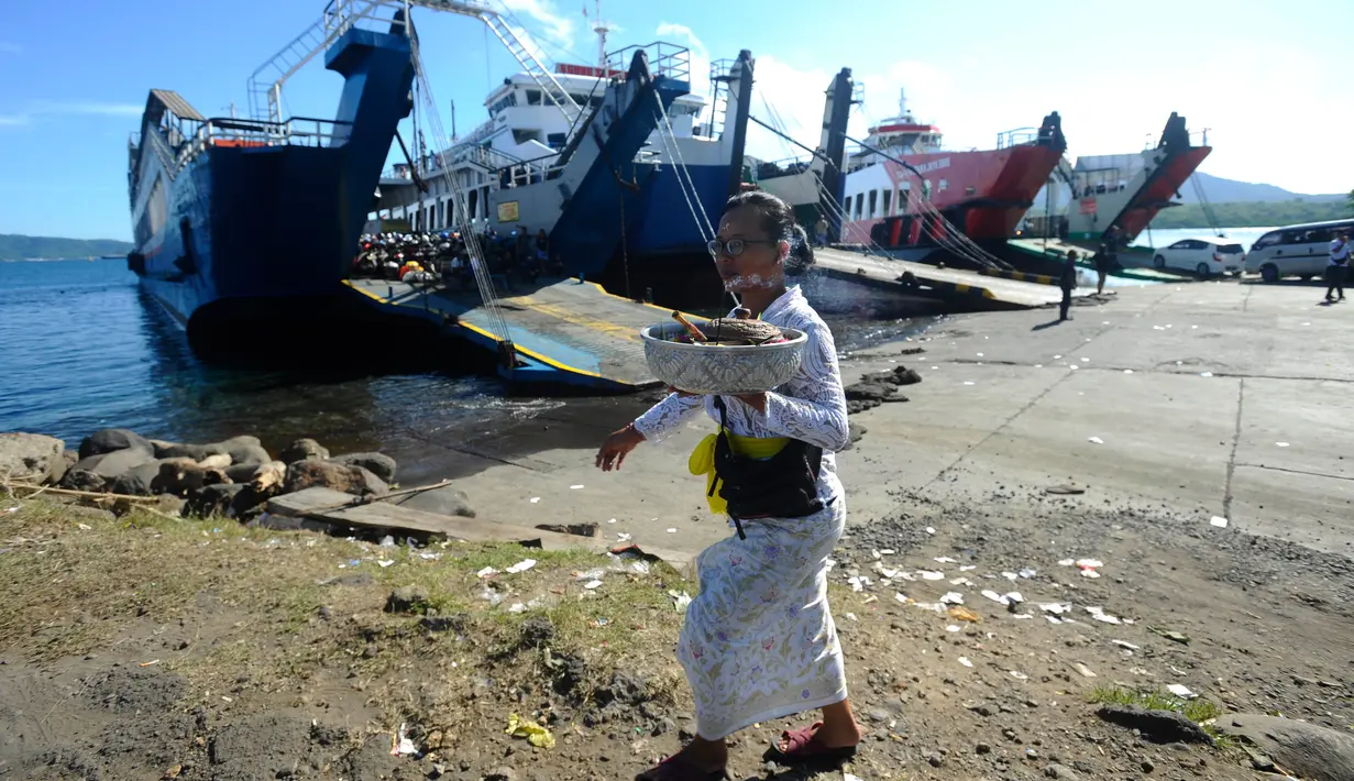 Umat Hindu Dharma membawa sesaji di depan dermaga kapal penyeberangan pada H-3 Lebaran Idul Fitri di Pelabuhan Gilimanuk, Bali, Rabu (19/4/2023). (merdeka.com/Arie Basuki)