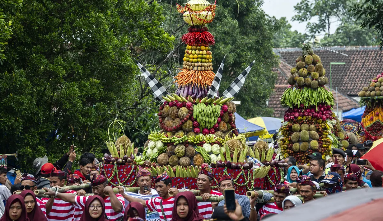Para peserta mengarak tumpeng durian selama festival Kenduren di Jombang, Jawa Timur, Minggu (3/3). Festival tersebut merupakan acara tahunan yang digelar setiap memasuki musim panen durian sebagai bentuk syukur petani kepada Tuhan (Juni Kriswanto/AFP)
