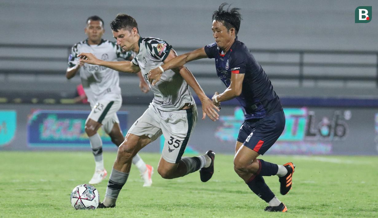 Pemain Persikabo 1973, Pushniakou Siarhei (kiri) berebut bola dengan pemain Arema FC, Rensi Yamaguchi dalam laga tunda pekan ke-17 BRI Liga 1 2021/2022 di Stadion I Wayan Dipta, Gianyar, Bali, Rabu (5/1/2022). (Bola.com/Nandang Permana)