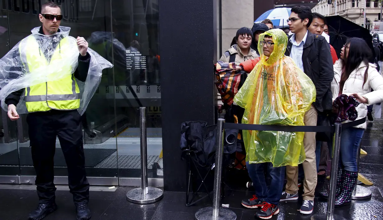 Pembeli rela hujan-hujanan menunggu dibukanya toko saat peluncuran resmi iPhone 6s, Sydney, Australia, (25/9/2015). iPhone 6s dibandrol dengan harga sekitar 12 juta - 15 juta rupiah, sedangkan 6s Plus 13 juta - 17 juta rupiah. (REUTERS/David Gray)