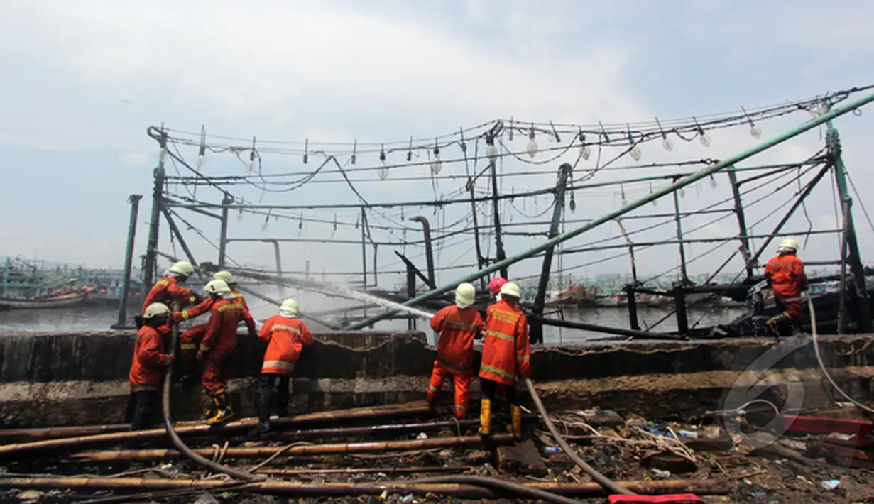 Sejumlah petugas pemadam kebakaran terus menyemprotkan air ke kapal nelayan yang terbakar di Pelabuhan Muara Angke, Jakarta, Jumat (27/2/2015). Diduga kebakaran disebabkan korsleting listrik. (Liputan6.com/Johan Tallo)