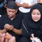 Artis komedi Tukul Arwana bersama anaknya berdoa saat pemakaman istrinya, Susiana, di TPU Tanah Kusir, Jakarta, Rabu (24/8). Susiana wafat di usia 48 tahun akibat penyakit asma yang dideritanya. (Liputan6.com/Immanuel Antonius)