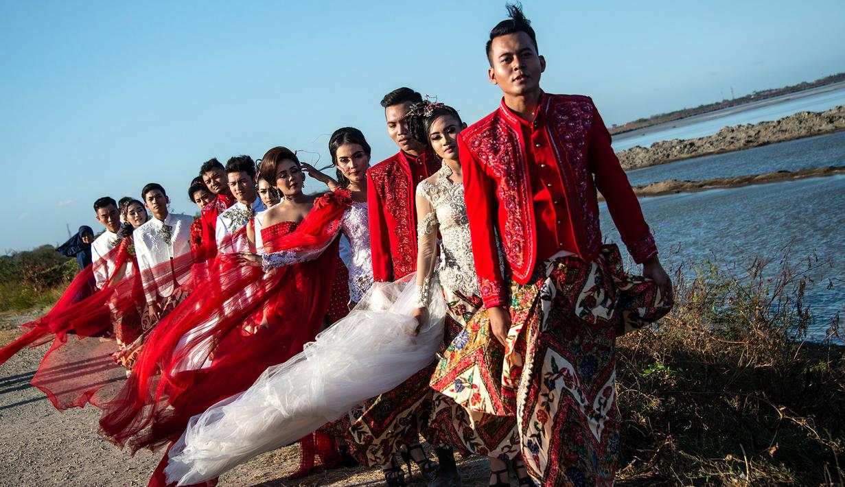 Model mengenakan busana kebaya bertema merah putih saat fashion show di tanggul Lapindo Porong, Sidoarjo, Jawa Timur, Selasa (13/8/2019). Peragaan busana yang menampilkan busana kebaya tersebut untuk memeriahkan HUT ke-74 kemerdekaan RI. (Photo by JUNI KRISWANTO / AFP)
