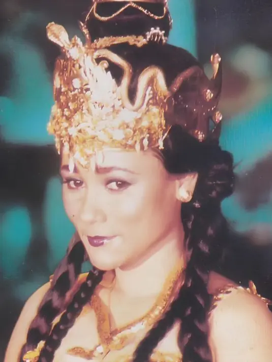 Suzzanna  tampil dengan atasan kemben keemasan serasi dengan aksesori kalung ular serta mahkota di rambutnya.  [@suzzannaofficial]