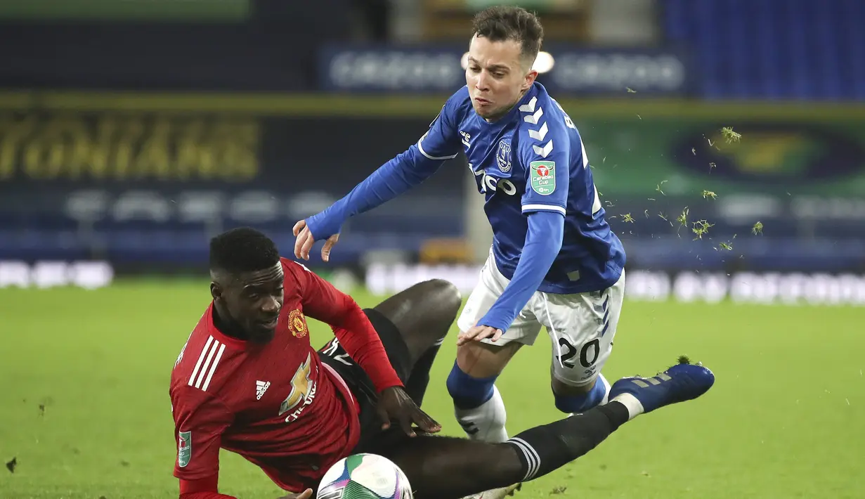 Striker Everton, Bernard (kanan), dijatuhkan bek Manchester United, Axel Tuanzebe, dalam laga perempatfinal Piala Liga Inggris Carabao Cup di Goodison park, Rabu (23/12/2020). Everton kalah 0-2 dari Manchester United. (AP/Nick Potts/Pool)