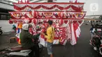 Seorang pedagang bendera merapikan umbul-umbul dan bendera yang di jual di Sepanjang Jalan Jatinegara, Jakarta, Selasa (2/8/2022). Jelang peringatan HUT Kemerdekaan RI ke-77, pedagang musiman bendera  mulai bermunculan mereka memanfaatkan trotoar untuk memajang dagangannya, mulai dari umbul-umbul, bendera, hingga ornamen khas merah putih lainnya dengan harga yang tawarkan juga bervariasi, mulai dari Rp. 5.000 ,- hingga Rp. 300.000,. (Liputan6.com/Faizal Fanani)