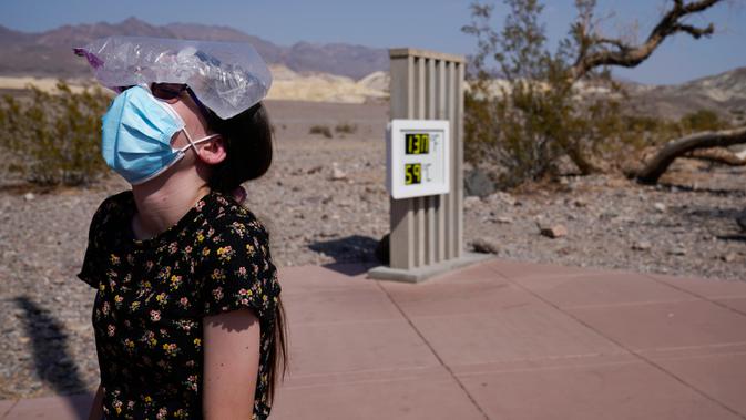 Katie Moore mendinginkan kepalanya dengan sekantong es di Taman Nasional Death Valley, California, AS, Senin (17/8/2020). Suhu terpanas di dunia terpantau terjadi di Taman Nasional Death Valley yang mencapai 130 derajat Fahrenheit (54,4 derajat Celcius) pada Minggu 16 Agustus. (AP Photo/John Locher)