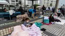Jumlah korban meninggal dan kritis maupun mengungsi terus diperbarui pihak berwenang setempat seiring berlangsungnya operasi di lapangan. Tampak dalam foto, warga beristirahat di dekat lokasi kebakaran yang terjadi pada hari Rabu di Wang Fuk Court, sebuah kompleks perumahan di distrik Tai Po, Wilayah Baru Hong Kong, Kamis 27 November 2025. (AP Photo/Chan Long Hei)