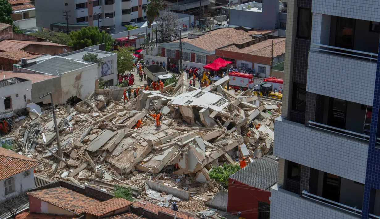 Petugas penyelamat menggali tumpukan puing-puing setelah sebuah bangunan runtuh di Fortaleza, negara bagian Ceara, Brasil, Selasa (15/10/2019). Pejalan kaki yang tengah melewati gedung ketika runtuh juga dibawa ke klinik medis terdekat. (RODRIGO PATROCINIO / AFP)
