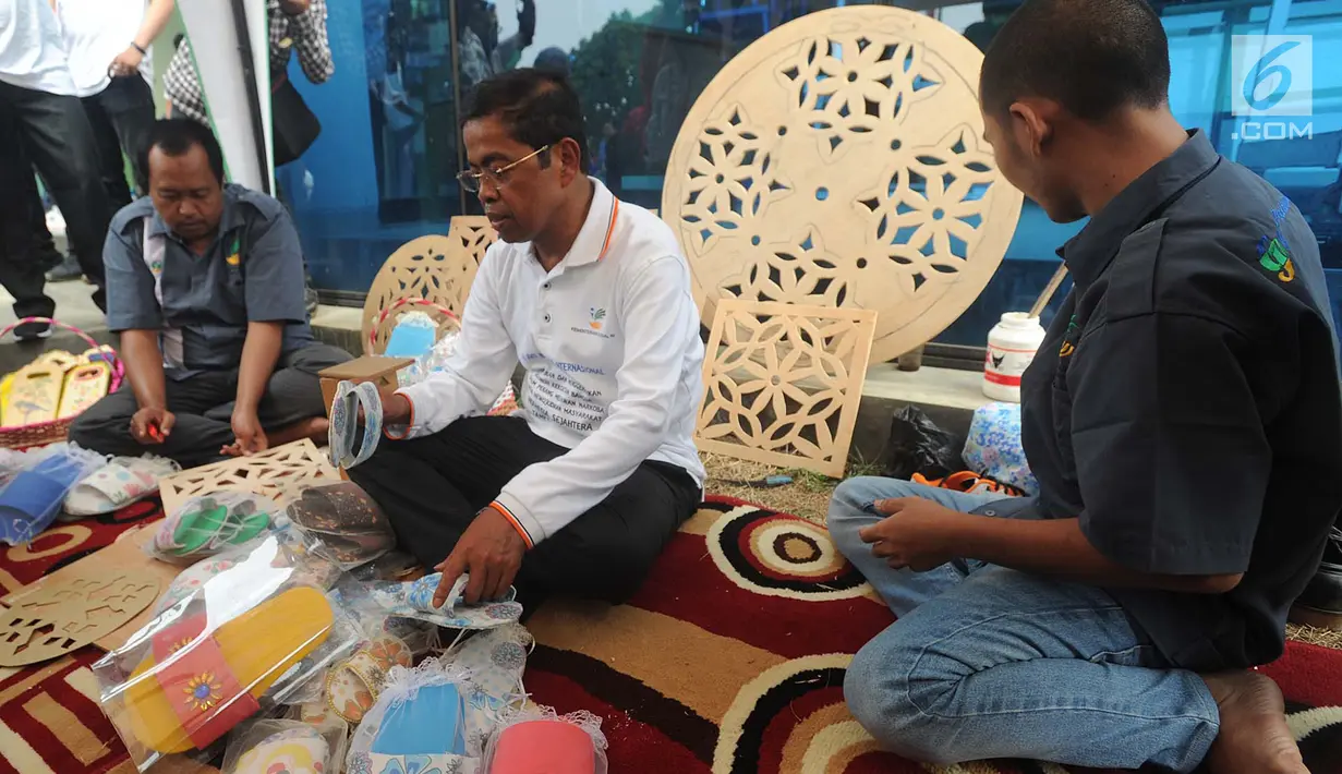 Menteri Sosial (Mensos) Idrus Marham (tengah) memperhatikan sandal buatan warga binaan di peringatan Hari Anti Narkoba Internasional di Panti Sosial Permadi Putra (PSPP) Galih Pakuan, Ciseeng, Bogor, Jawa Barat, Rabu (1/8). (Merdeka.com/Arie Basuki)