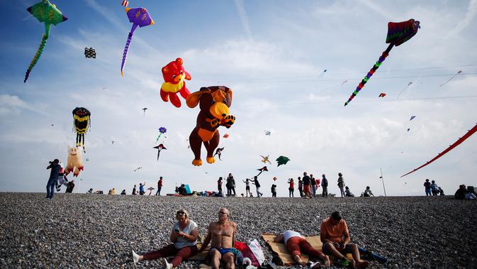 Orang-orang menerbangkan layang-layang selama Festival Layang-layang Internasional Dieppe ke-20 di Dieppe, Prancis, Minggu (9/9). Festival setiap dua tahun sekali sejak 1980 itu menjadi festival layang-layang terbesar di Eropa. (AFP/CHARLY TRIBALLEAU)