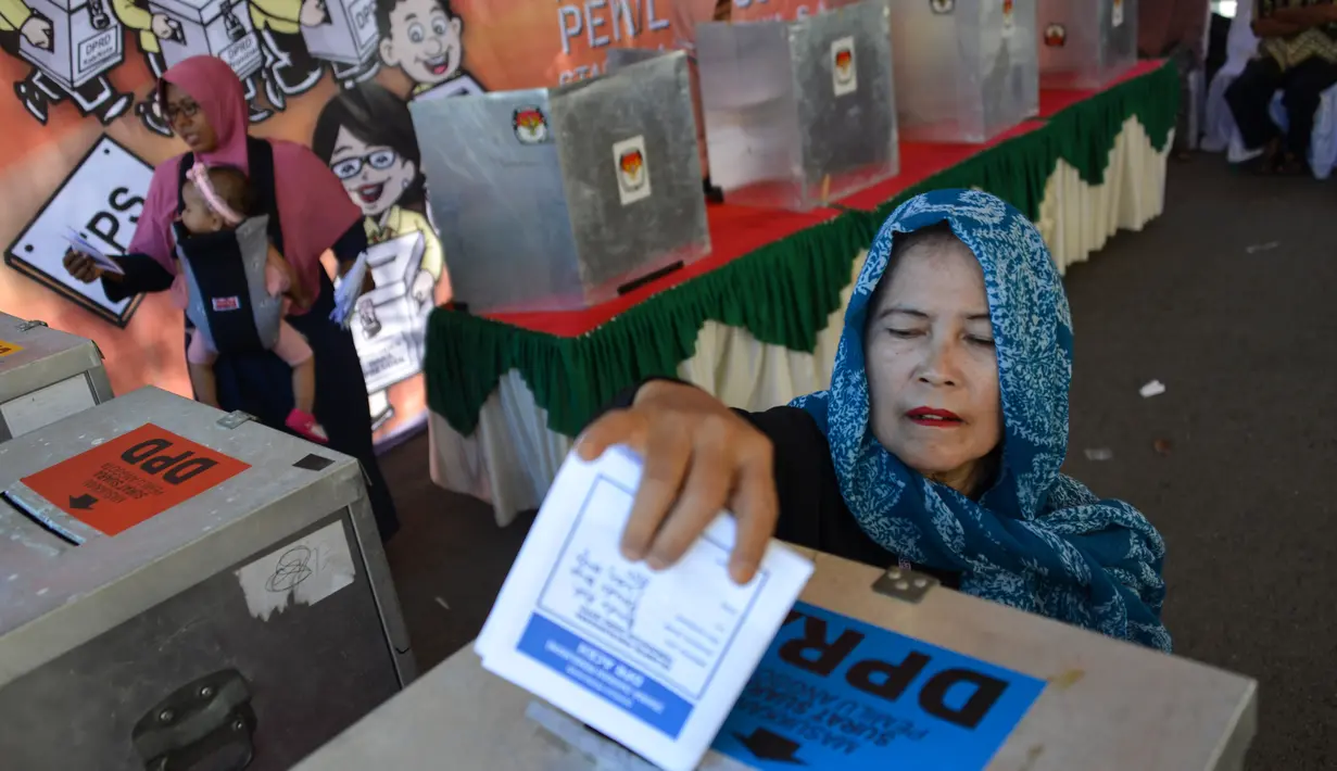 Seorang wanita memasukan kertas suaranya saat latihan pra-pemilihan di Banda Aceh, provinsi Aceh (6/4). Indonesia akan menyelenggarakan Pemilu serentak pada 17 April 2019. (AFP Photo/Chaideer Mahyudin)