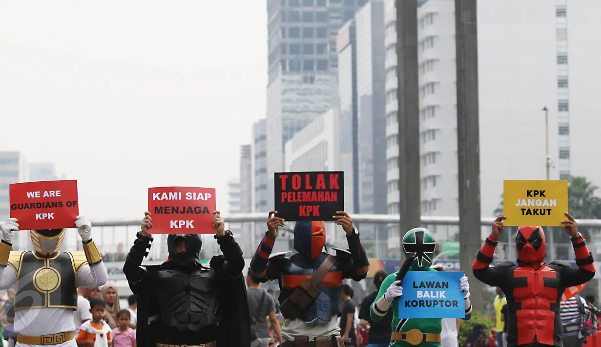 Sejumlah superhero menunjukkan poster saat melakukan aksi teaterikal di Bundaran HI, Jakarta, Minggu (16/4). Dalam aksi teaterikal tersebut para superhero menyuarakan untuk terus mendukung KPK. (Liputan6.com/Angga Yuniar)