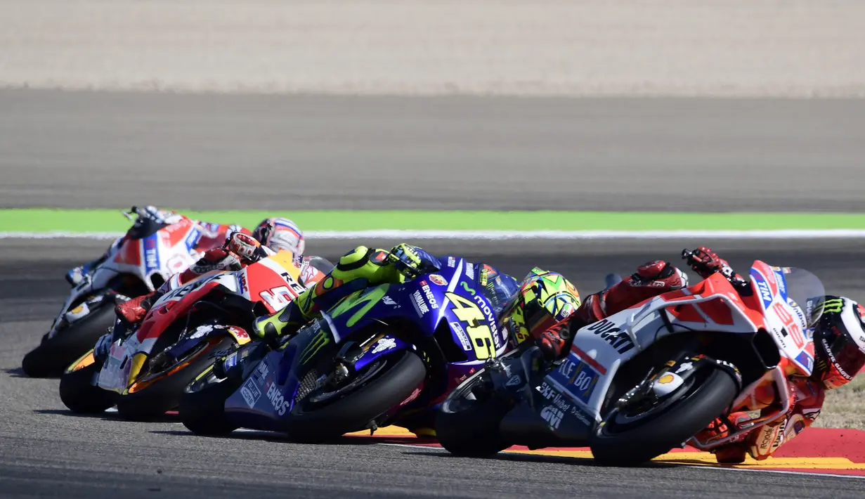 Pebalap Movistar Yamaha, Valentino Rossi, berusaha membalap pebalap Ducati, Jorge Lorenzo pada GP Aragon di Sirkuit Motorland, Alcaniz, Minggu (24/9/2017). Lorenzo finis ketiga dengan waktu 42 menit 8,844 detik. (AFP/Javier Soriano)