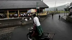 Siswa bermain di halaman sekolah dengan latar belakang pemandangan Gunung Sindoro yang tertutup kabut sebelum dimulainya kegiatan belajar di Gedung Sekolah Dasar (SD) Negeri 2 Bowongso, Kecamatan Kalikajar, Wonosobo, Jawa Tengah (2/4). (merdeka.com/Iqbal S. Nugroho)