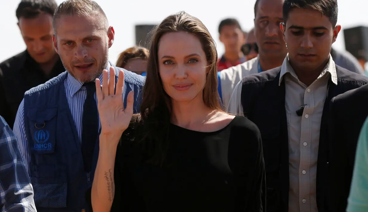 Angelina Jolie melambaikan tangan kepada awak media saat berkunjung ke kamp pengungsi Azraq untuk Suriah, Yordania, Jumat (9/9). Jolie menyebut reputasi PBB saat ini telah dirusak oleh oknum pasukan penjaga perdamaian. (REUTERS / Muhammad Hamed)