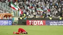 Pemain Suriah sujud usai menahan imbang Iran 2-2 pada laga kualifikasi Piala Dunia 2018 di Stadion Azadi, Taheran, Selasa (5/9/2017). Finis urutan tiga grup A, Suriah lolos ke babak playoff untuk menantang Australia. (AFP/Atta Kenare)