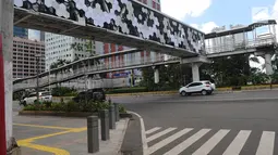 Kendaraan melintas di Jalan Jenderal Sudirman, Jakarta, Jumat (4/1). Jembatan penyeberangan orang (JPO) Dukuh Atas saat ini sudah bisa dilintasi pejalan kaki. (Liputan6.com/Herman Zakharia)