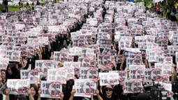 Spanduk yang dibawa para pengunjuk rasa berisi slogan-slogan yang berbunyi "Meloloskan (RUU Pemulihan Hak Guru) pada Sidang Parlemen bulan September."  (AP Photo/Ahn Young-joon)
