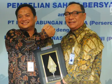 Dirut PT Bank Tabungan Negara (Persero) Tbk. Maryono (kanan) berjabat tangan dengan Dirut PT Permodalan Nasional Madani (Persero) (PNM) Arief Mulyadi usai penandatanganan perjanjian pembelian saham bersyarat PNMIM dari PNM di Kementerian BUMN, Jakarta, Senin (22/4). (Liputan6.com/Angga Yuniar)