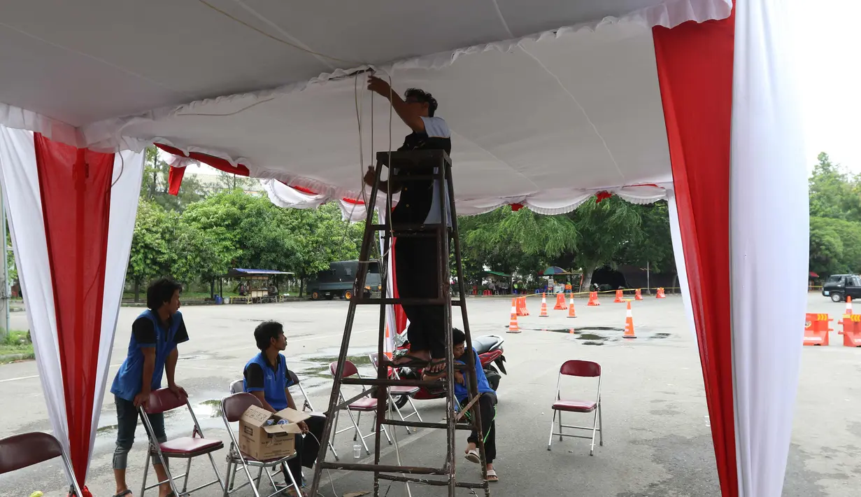 Petugas memasang sebuah tenda pengamanan di sekitar Stadion Manahan, Solo, Selasa (7/11). Lokasi itu telah disiapkan panitia sebagai salah satu kantong parkir kendaraan tamu acara pernikahan Kahiyang Ayu dan Bobby Nasution. (Liputan6.com/Angga Yuniar)