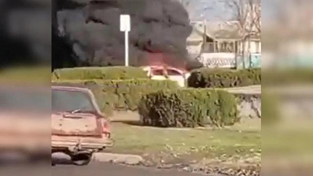 Rekaman video yang tidak diverifikasi dari dugaan serangan yang diposting online menunjukkan asap abu-abu tebal dan api membumbung ke udara di atas sebuah mobil di Ukraina. (Screenshot Twitter)