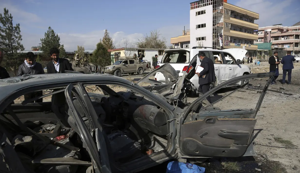 Personel keamanan Afghanistan berkumpul di lokasi serangan bom mobil di Kabul, Afghanistan (13/11/2019). Setidaknya tujuh orang tewas dan tujuh lainnya luka-luka ketika sebuah bom mobil meledak pada jam sibuk pagi hari Kabul pada 13 November. (AP Photo/Rahmat Gul)