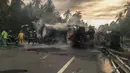 Petugas berusaha memadamkan api yang masih tersisa akibat tabrakan antara sebuah bus dengan truk tangki bahan bakar (BBM) di negara bagian Guerrero, Meksiko, Kamis (14/4). Penyebab tabrakan belum diketahui secara pasti. (HO/Guerrero Civil Protection/AFP)