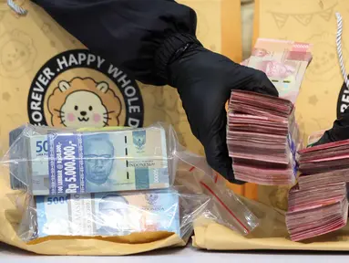 Petugas menunjukkan barang bukti berupa uang tunai yang disita dari Operasi Tangkap Tangan (OTT) terhadap Bupati Cilacap, Jawa Tengah, Syamsul Auliya Rachman, di Gedung Merah Putih Komisi Pemberantasan Korupsi (KPK), Jakarta, Sabtu (14/3/2026). Komisi Pemberantasan Korupsi (KPK) resmi menetapkan dua tersangka dalam Operasi Tangkap Tangan (OTT) di wilayah Kabupaten Cilacap, Jawa Tengah, salah satunya adalah Bupati Cilacap,  Syamsul Auliya Rachman. (Liputan6.com/Helmi Fithriansyah)