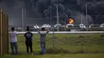 Warga mengamati kebakaran pabrik TPC Group yang meledak di Port Neches, Texas (27/11/2019). Dua ledakan besar 13 jam terpisah membakar pabrik kimia dan menyebabkan tiga pekerja terluka. (Marie D. De Jesús/Houston Chronicle via AP)