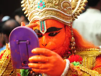 Seorang pemuja Hindu India berpakaian seperti dewa monyet Hanoman bersiap mengikuti festival Jayanti di Allahabad, India (18/10). Festival ini untuk memperingati kelahiran dewa Hindu Hanoman. (AFP Photo/Sanjay Kanojia)