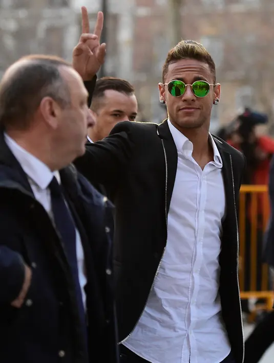 Neymar menyapa awak media usai memberikan kesaksian di hadapan hakim di Madrid, Spanyol, (2/2). Neymar dipanggil untuk memberikan bukti atas transfer dirinya dari Santos ke Barcelona pada tahun 2013. (AFP PHOTO/AVIER Soriano)