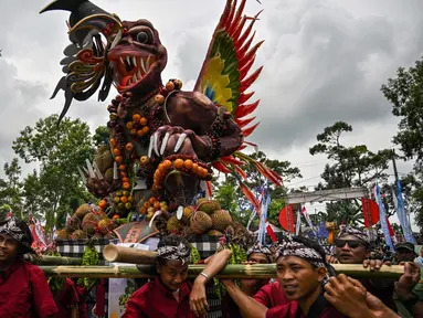 Warga mengarak kendaraan hias berisi durian dan buah lainnya selama festival durian “Kenduren Wonosalam” di desa Wonosalam, Jombang, Jawa Timur, 23 Februari 2025. (JUNI KRISWANTO/AFP)