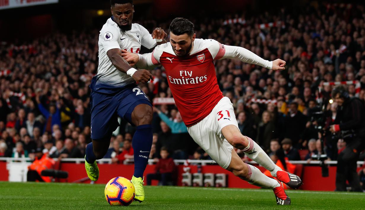 Bek sayap Arsenal, Sead Kolasinac berduel dengan pemain Tottenham hotspur, Serge Aurier dalam laga lanjutan Liga Inggris pekan ke-14 yang berlangsung di stadion Emirates, London, Minggu (2/12). Arsenal menang atas Tottenham Hotspur 2–1. (AFP/Ian Kington)