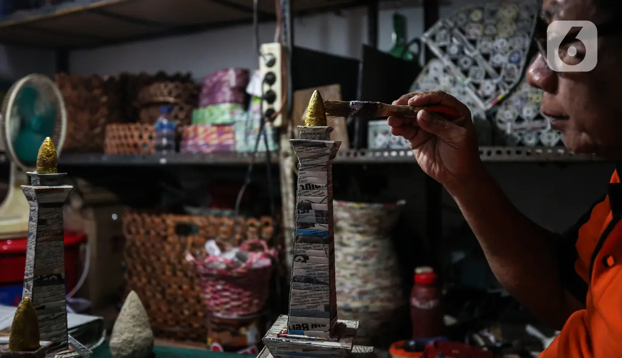 Sugito (68) menyelesaikan pembuatan miniatur Monas dari kertas koran bekas di Bank Sampah Tri Alam Lestari, Jakarta Selatan, Rabu (9/6/2021).  Barang kerajinan yang dibuat Sugito di antaranya tempat tisu, lampu hias, wadah buah, tatakan gelas, dan wadah air mineral. (Liputan6.com/Johan Tallo)