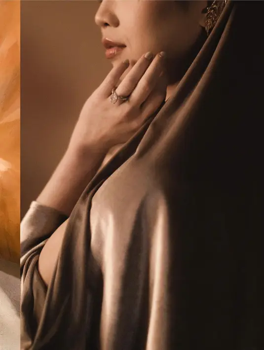 Dress-nya warna emas itu hadir dengan material velvet yang memberi impresi mewah. [@clarissatanoe].