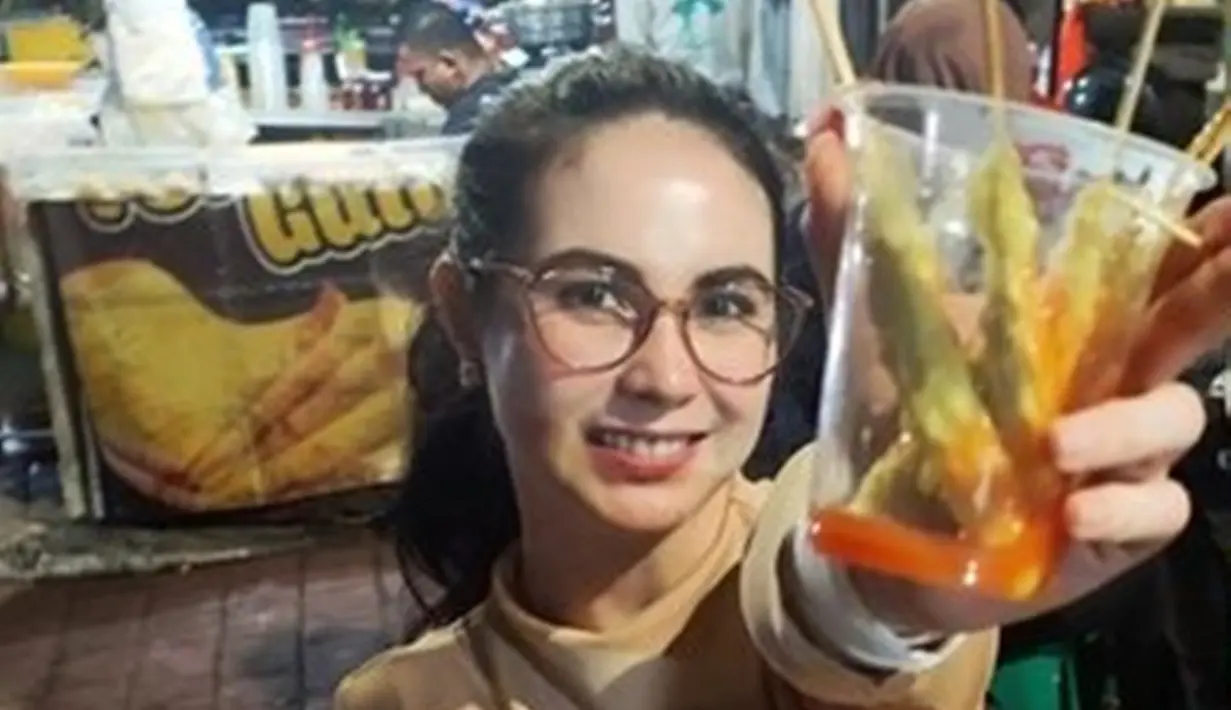 Arumi Bachsin baru saja mengunggah momen ia beli jajan di pasar malam. Ia tampak sumringah saat menjajal telur gulung. Momen Arumi Bachsin jajan telur gulung pun banjir pujian karena ia tak merasa gengsi jajan pinggir jalan. (Liputan6.com/IG/arumibachsin_94)